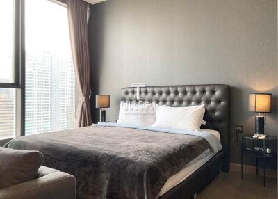 Elegant bedroom with a large bed, stylish headboard, and city view