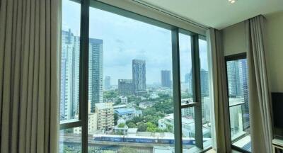 Spacious living room with large windows offering cityscape view