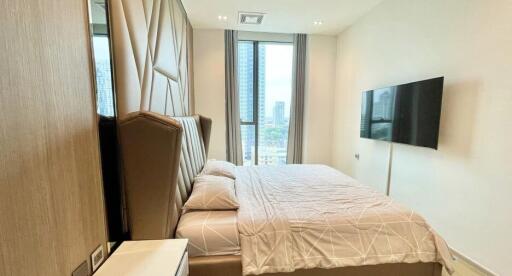 Modern bedroom with city view through large windows