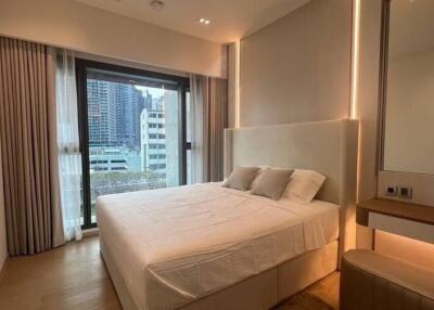 Modern bedroom with large bed, ambient lighting, and city view