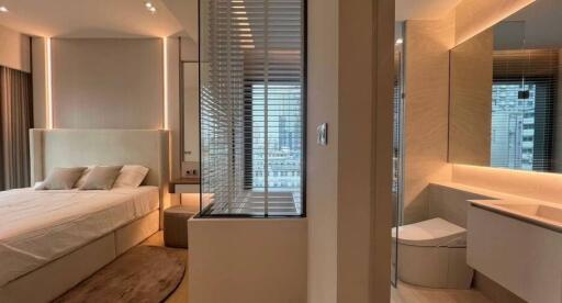 Modern bedroom with integrated bathroom design featuring ample lighting and city view