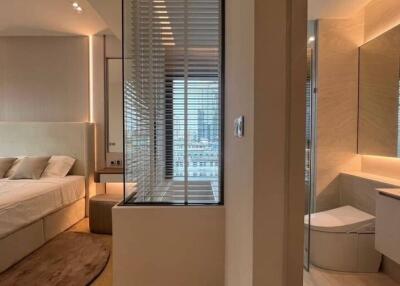 Modern bedroom with integrated bathroom design featuring ample lighting and city view