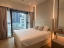 Modern bedroom with a large bed and extensive city view through floor-to-ceiling windows