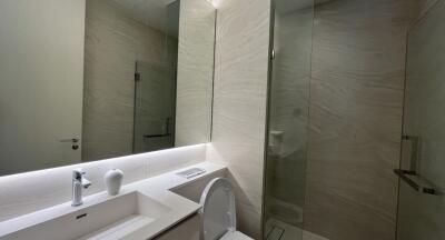 Modern bathroom with marble finishes and well-lit vanity area