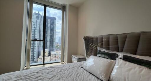 Modern bedroom with cityscape view through large window