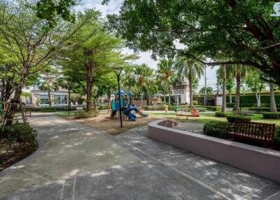 Well-maintained community playground with lush greenery