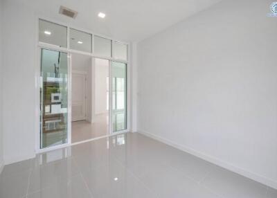 Bright and spacious building interior with glossy white tiled flooring and large glass doors