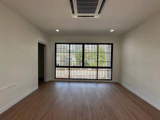 Spacious living room with large windows and wooden flooring