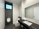 Modern bathroom with wall-mounted urinal, toilet, and sleek vanity