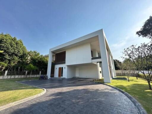 Modern white two-story house with spacious driveway and garden