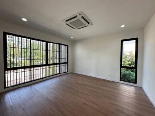 Spacious living room with large windows and hardwood flooring