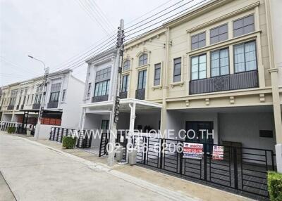 Exterior view of modern townhouses with balconies and parking