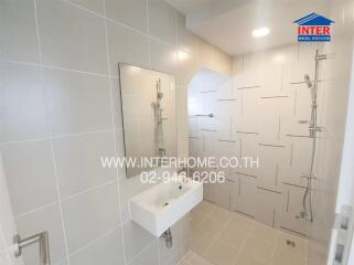 Modern bathroom with white tiles and ample lighting