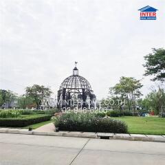 Elegant dome-shaped gazebo in a landscaped garden with pathways