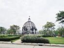 Elegant dome-shaped gazebo in a landscaped garden with pathways