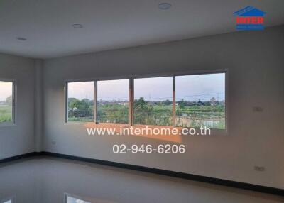 Spacious living room with large windows overlooking green fields
