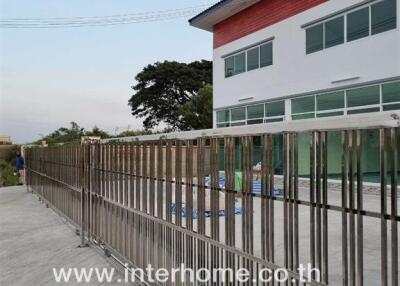 Exterior view of a modern two-story building with fence