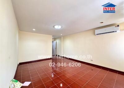 Spacious hallway with red tiled flooring and mounted air conditioner