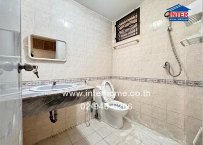 Spacious and well-lit tiled bathroom with modern fixtures