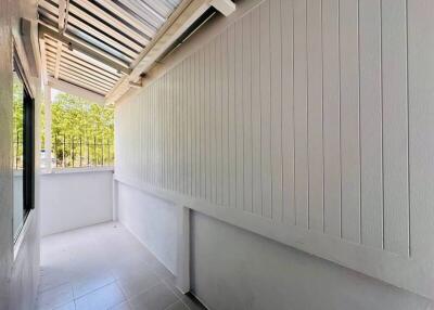 Bright and airy covered balcony with wooden slat privacy wall