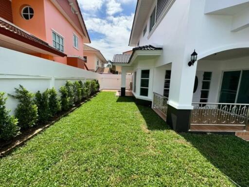 Spacious side lawn with green grass between two residential homes