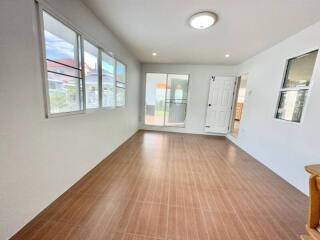 Spacious and well-lit living room with large windows and tile flooring