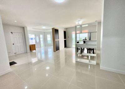 Spacious and well-lit living room with white glossy floor tiles