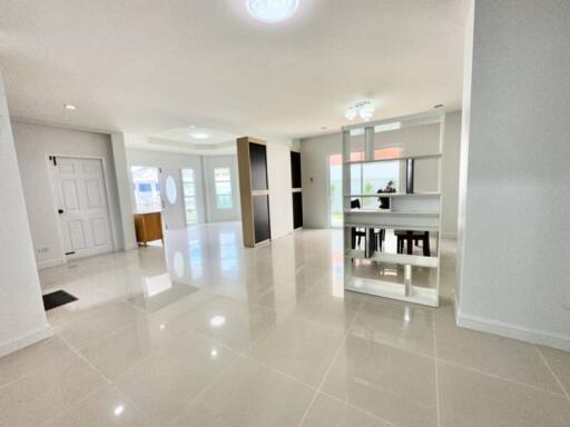 Spacious and well-lit living room with white glossy floor tiles