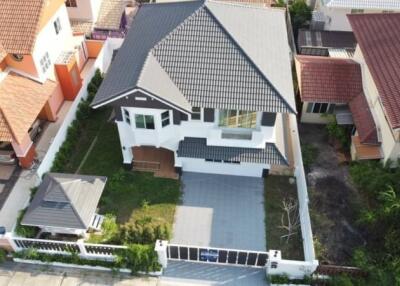 Aerial view of a modern suburban home with a well-maintained yard and solar panels