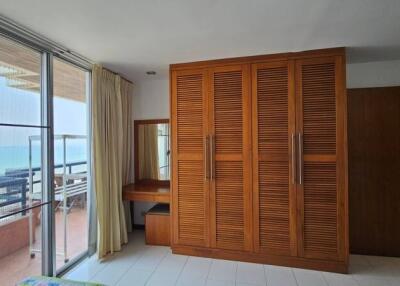 Spacious bedroom with ocean view and large wooden wardrobe