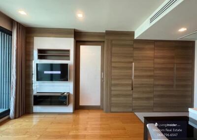 Modern bedroom with built-in wooden wardrobes and entertainment unit
