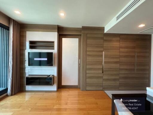 Modern bedroom with built-in wooden wardrobes and entertainment unit