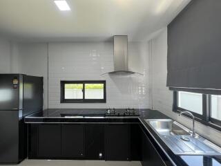 Modern kitchen with black countertops and stainless steel appliances