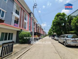 Exterior view of a residential townhouse complex with parked cars