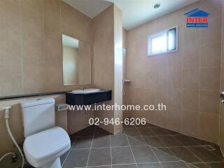 Modern bathroom with beige tiles and abundant natural light