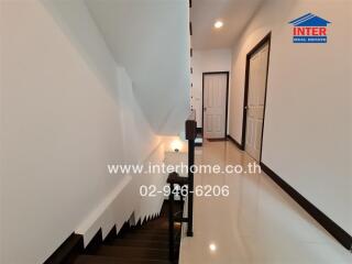 Modern hallway interior with white walls and stair leading to upper floor