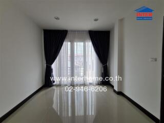 Spacious and bright living room with large windows and curtain