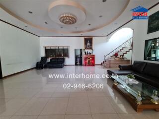 Spacious living room with modern decor and staircase