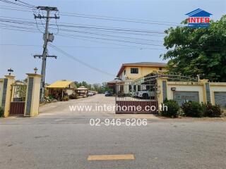 Gated entrance to a residential property with adjacent houses