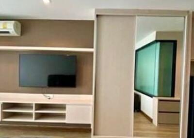 Modern living room with television and sliding door to the bedroom