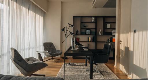 Modern home office with large desk, ergonomic chairs, and wooden bookshelf