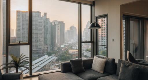 Cozy living room with modern sofa, large windows, and city view