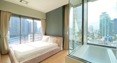 Modern bedroom with large windows showing cityscape