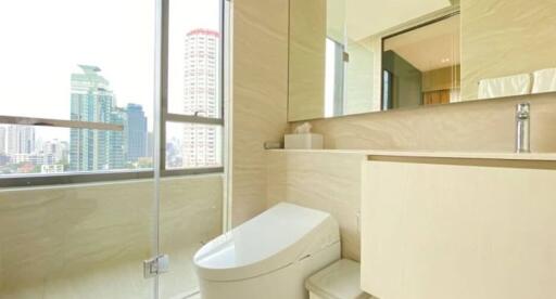 Modern bathroom with glass shower and city view