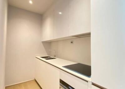 Modern narrow kitchen with white cabinetry and built-in appliances