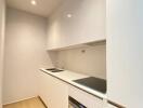 Modern narrow kitchen with white cabinetry and built-in appliances