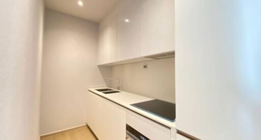 Modern narrow kitchen with white cabinetry and built-in appliances