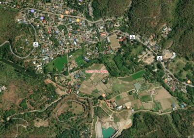 Aerial view of a mixed rural and residential area with marked plots for sale