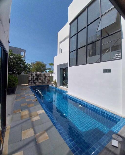 Modern home with outdoor swimming pool and large windows