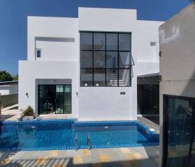 Modern two-story white residential building with a swimming pool